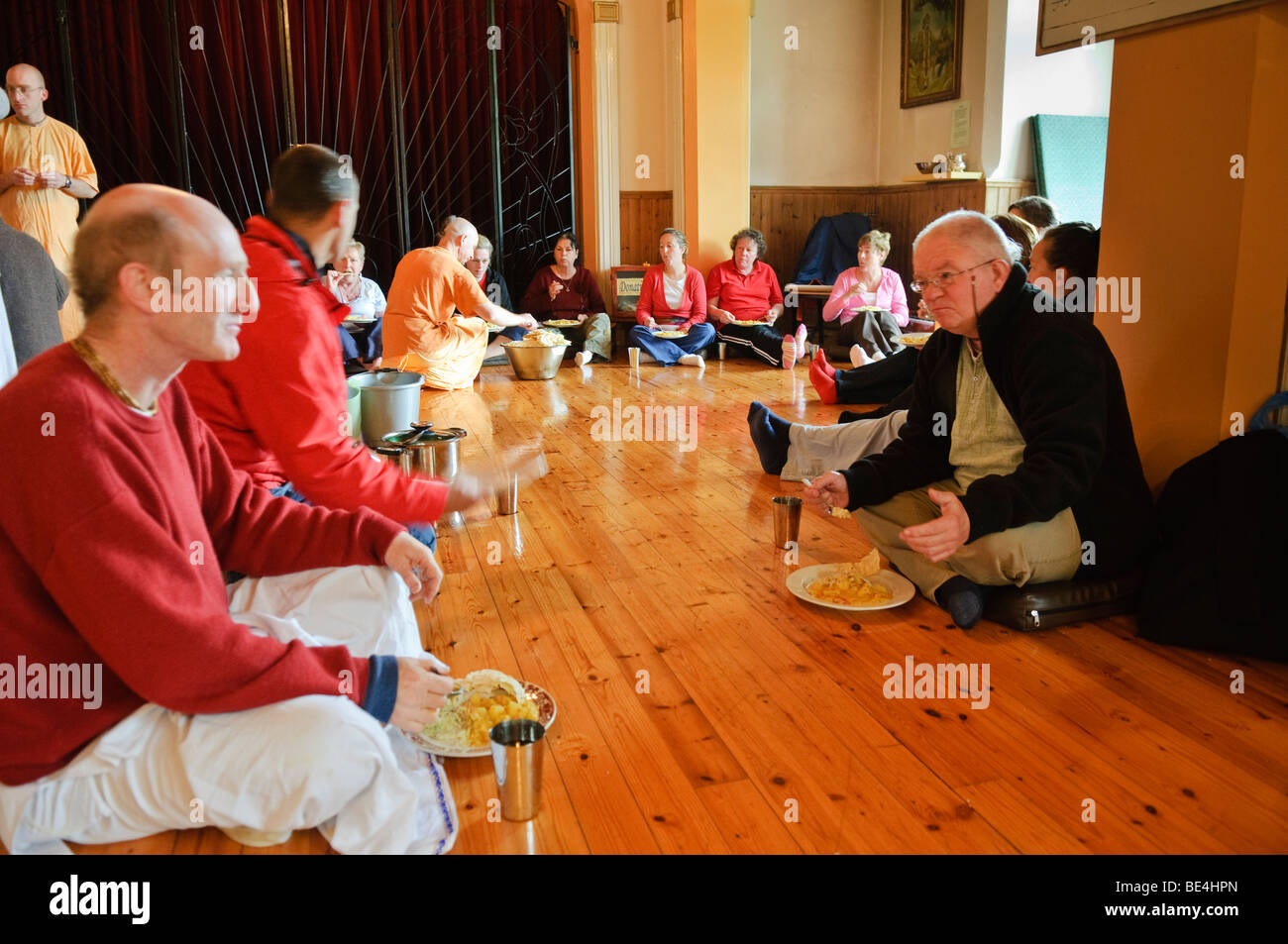 ISKCON Hare Krishna jünger und Besucher essen Vegetarier fest in einem Tempel Zimmer Stockfoto