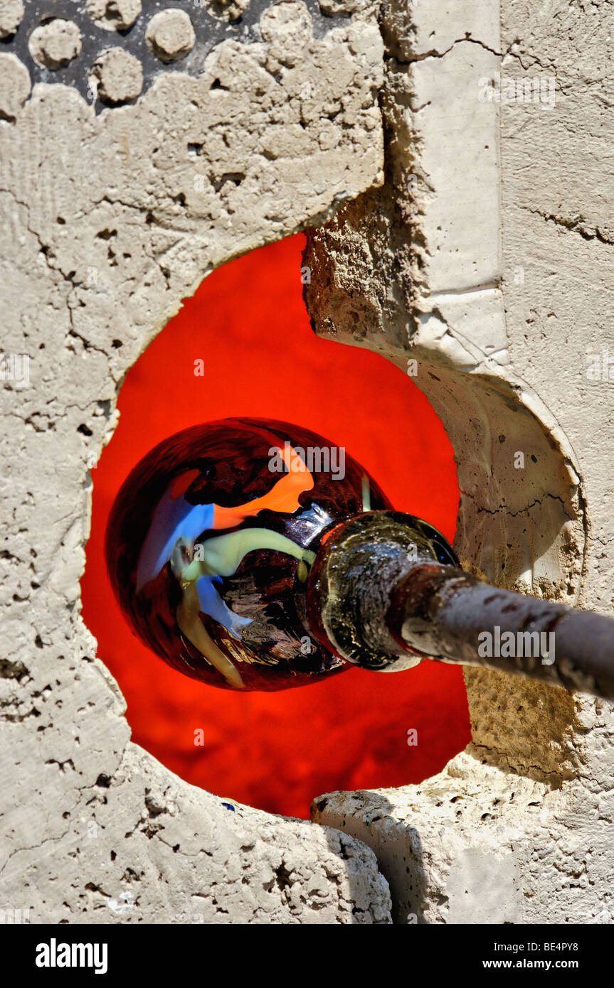 Ein Stück von geblasen Glas wird in Gas-Ofen aufgewärmt Stockfoto