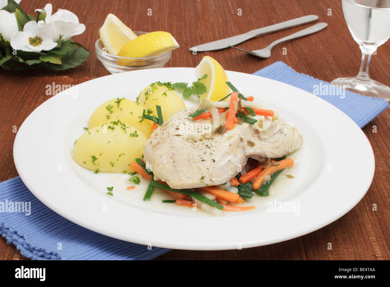 Gedünsteter Seelachs-Filet auf einem Bett aus bunten Gemüse mit Salzkartoffeln Stockfoto