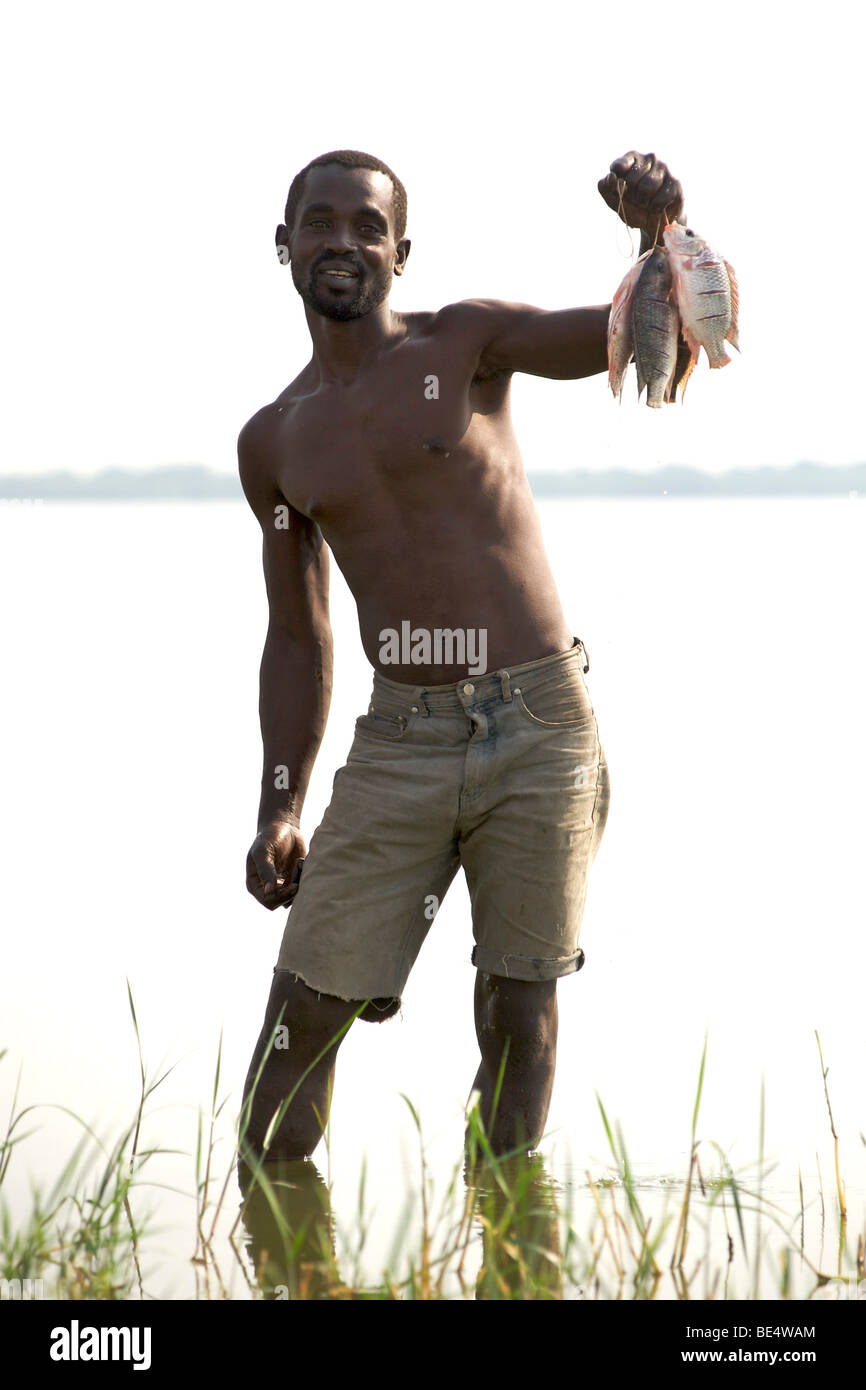 Ugandische Mann mit Tilapia Fisch am Kasenyi Dorf am Ufer des Lake