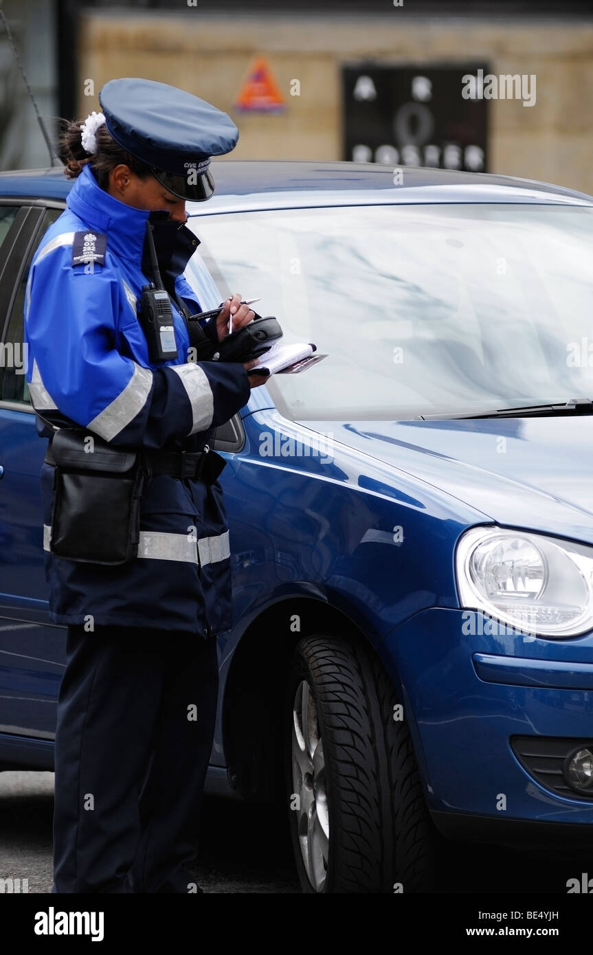 Traffic Warden schreiben ein Ticket für ein falsch geparktes Fahrzeug, Oxford, England, Vereinigtes Königreich. Stockfoto