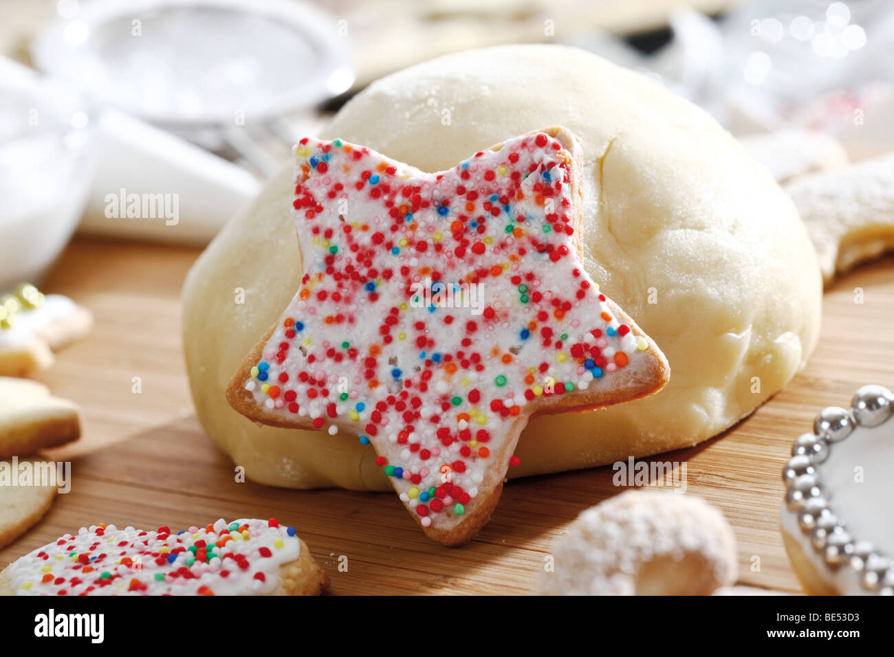 Sternförmige Mürbeteig Plätzchen mit Zucker-Perlen, Szene mit Kugel aus ... Sternförmige Mürbeteig Plätzchen mit Zucker-Perlen, Szene mit Kugel aus ...