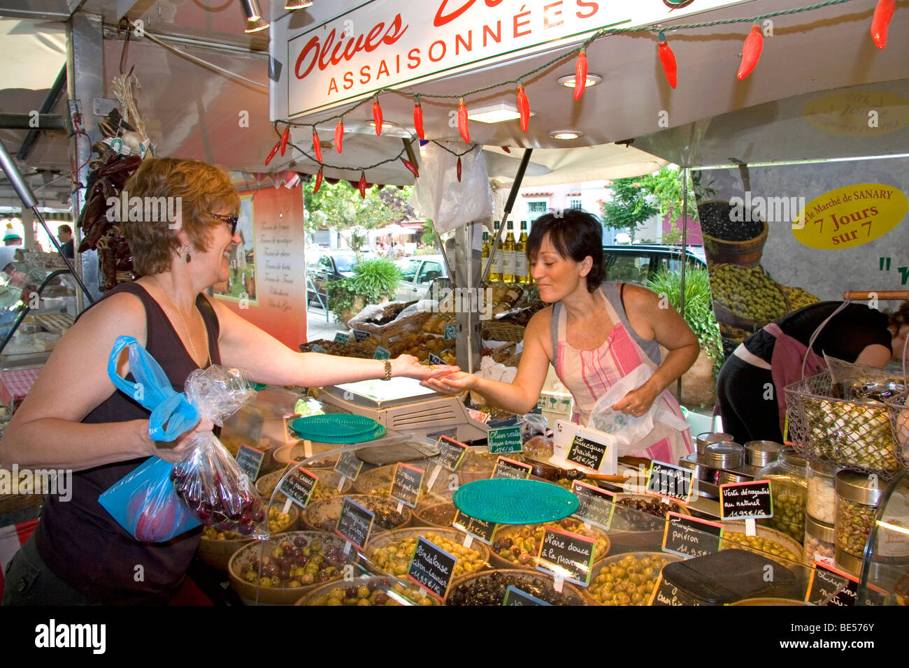 Kunden kaufen produzieren bei einem outdoor-Markt Anbieter in Sanary Sur Mer, Südfrankreich. Stockfoto