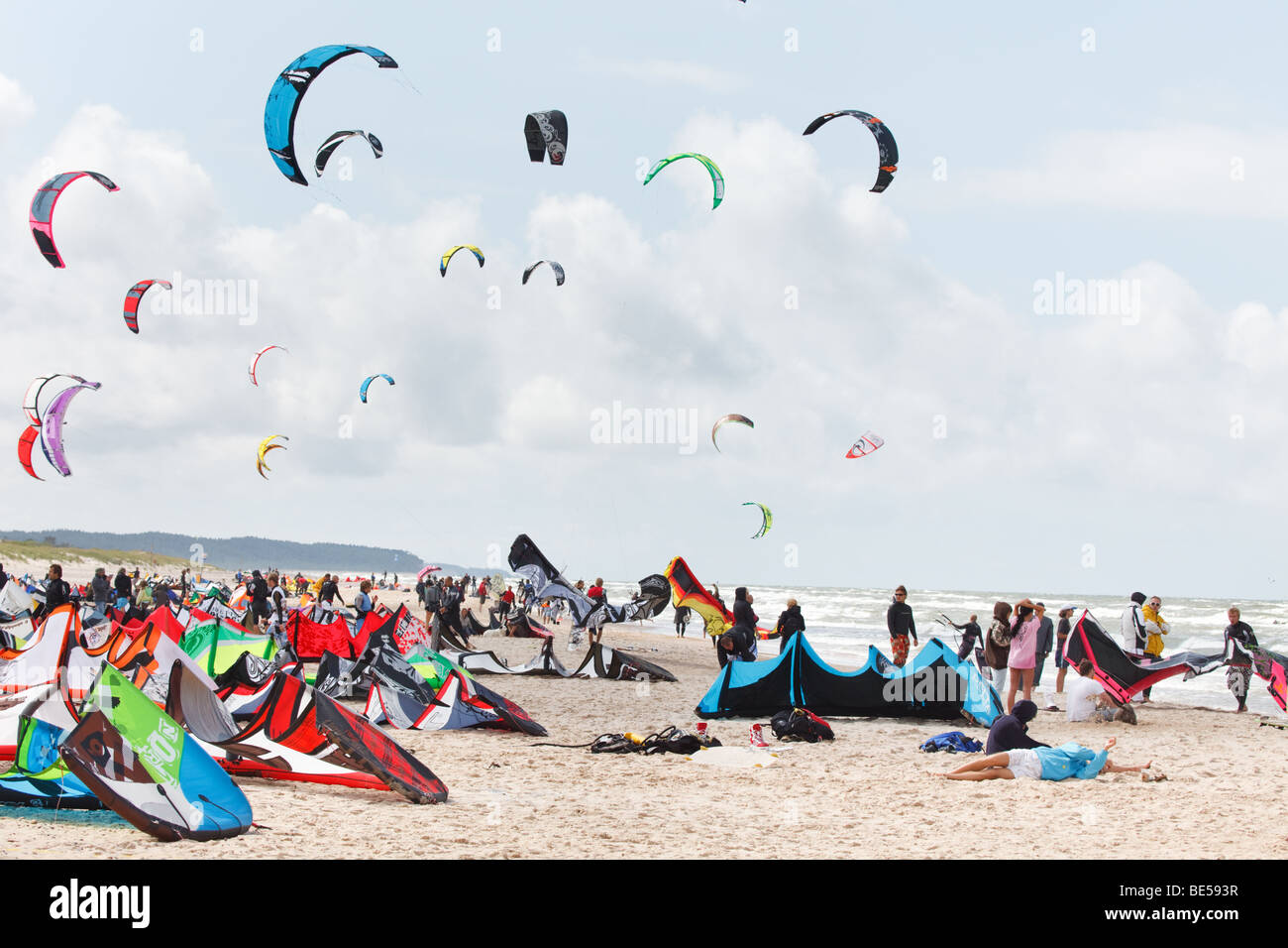 Kiteboarding-Wettbewerb mit vielen aktiven Menschen und Drachen fliegt hoch in den Himmel Stockfoto