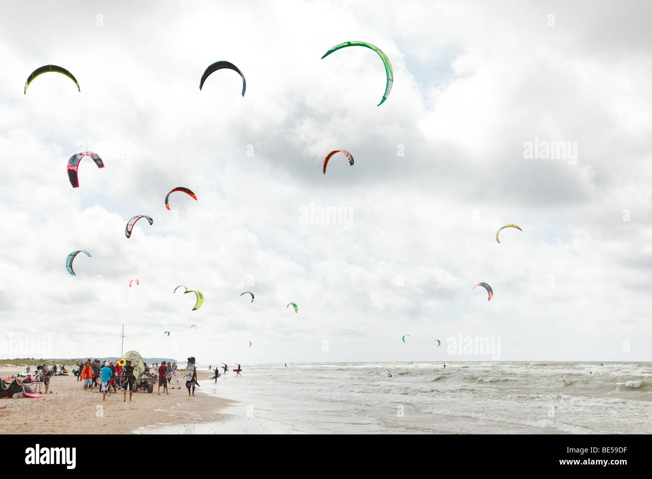 Kiteboarding-Wettbewerb mit vielen aktiven Menschen und Drachen fliegt hoch in den Himmel Stockfoto