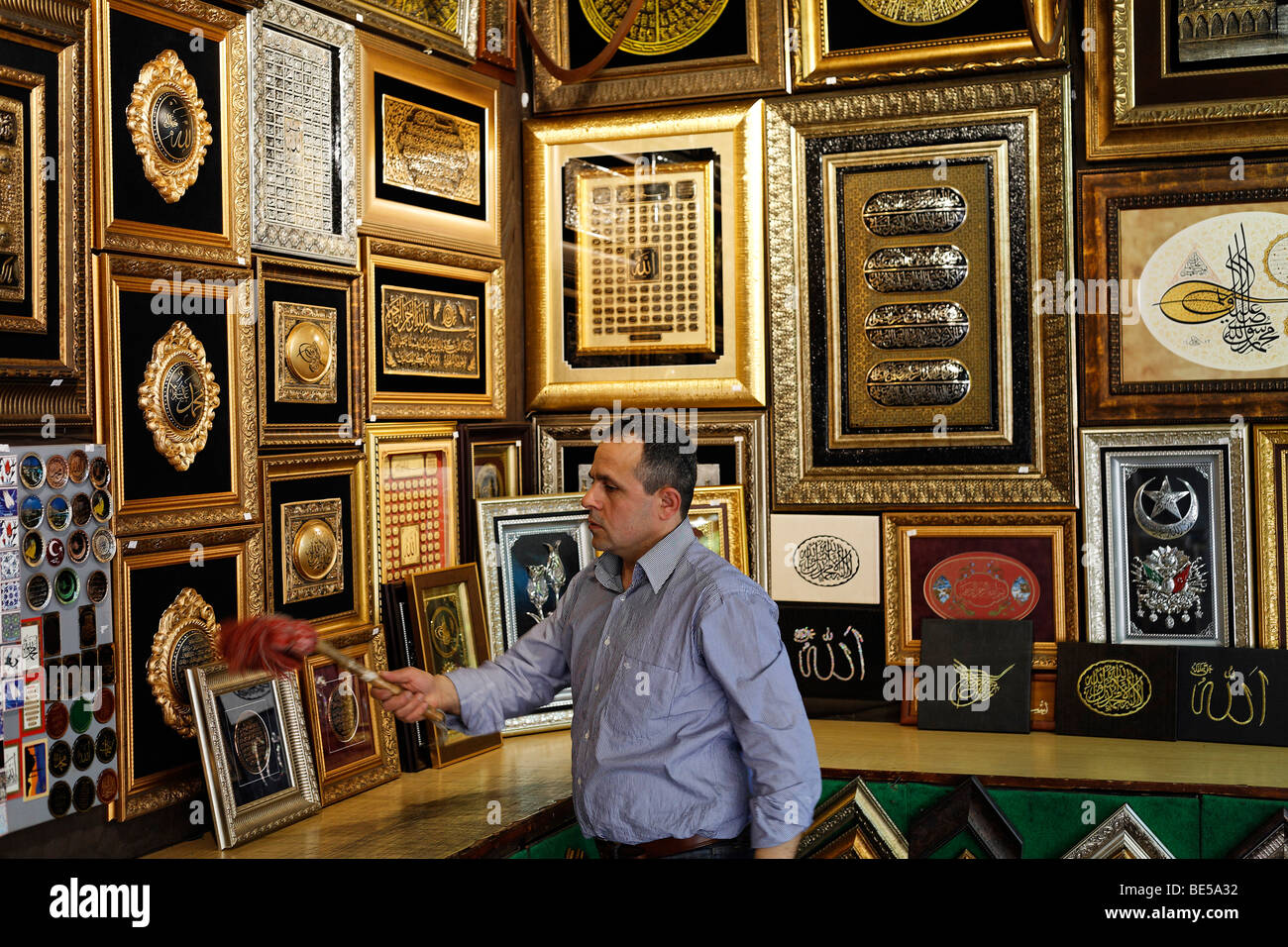 Bürsten den Staub von Goldrahmen mit kalligraphische Embleme, Mann buchen Basar Beyazit-Platz, Istanbul, Türkei Stockfoto