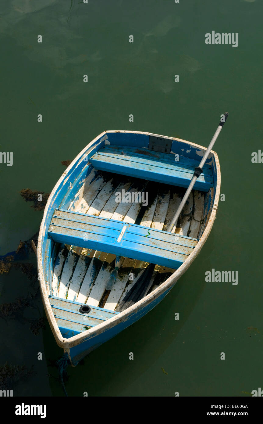 Eine abgenutzte kleine Ruderboot in ein grünes Meer schweben Stockfoto