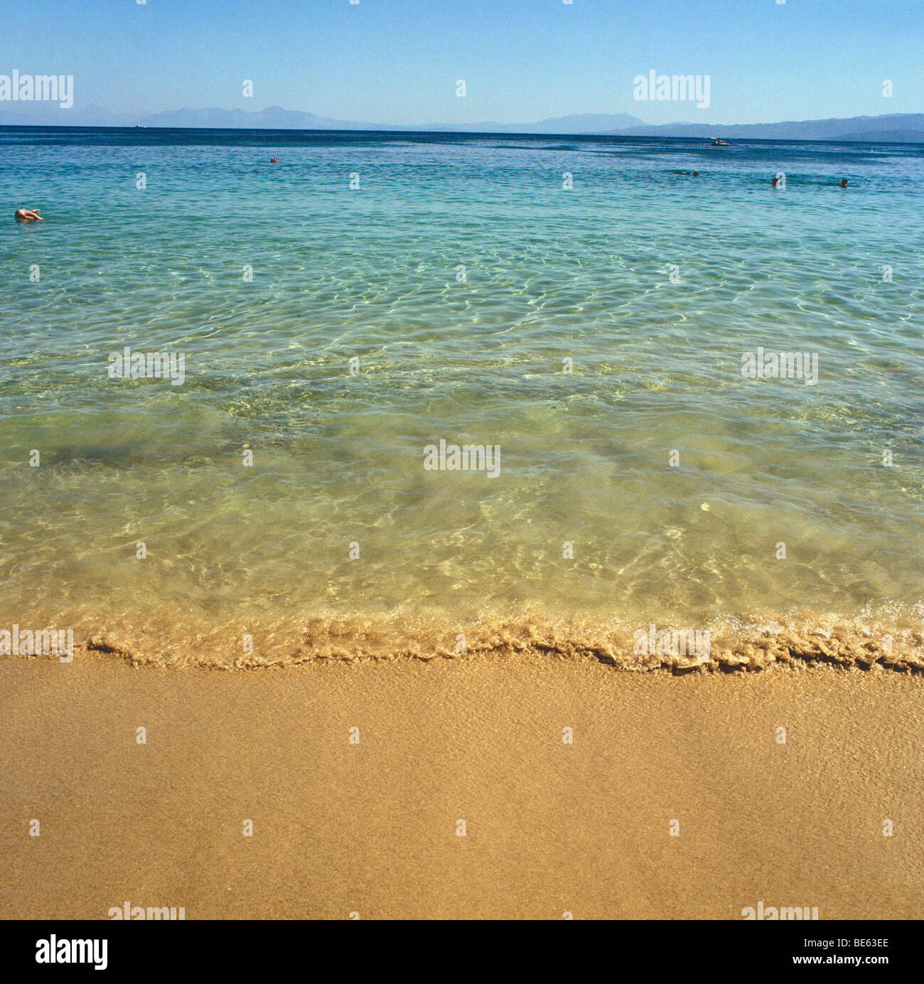 Meer auf der Insel Skithos mit kleinen Wellen am Ufer brechen zwei Schwimmer im tieferen Wasser in einem Abstand Stockfoto