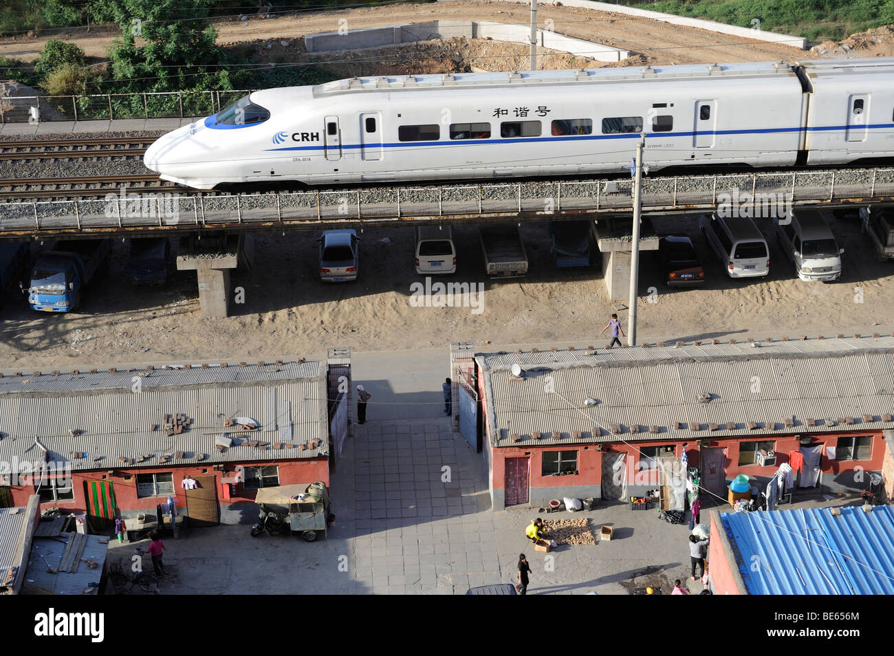 Ein CRH-Hochgeschwindigkeitszug China Railway High-Speed durchläuft eine Migrantengemeinschaft in Peking. 21 Sep 2009 Stockfoto