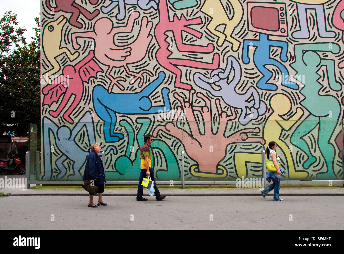 Menschen, die vorbeigehen ein Keith Haring Wandbild in Pisa Stockfoto