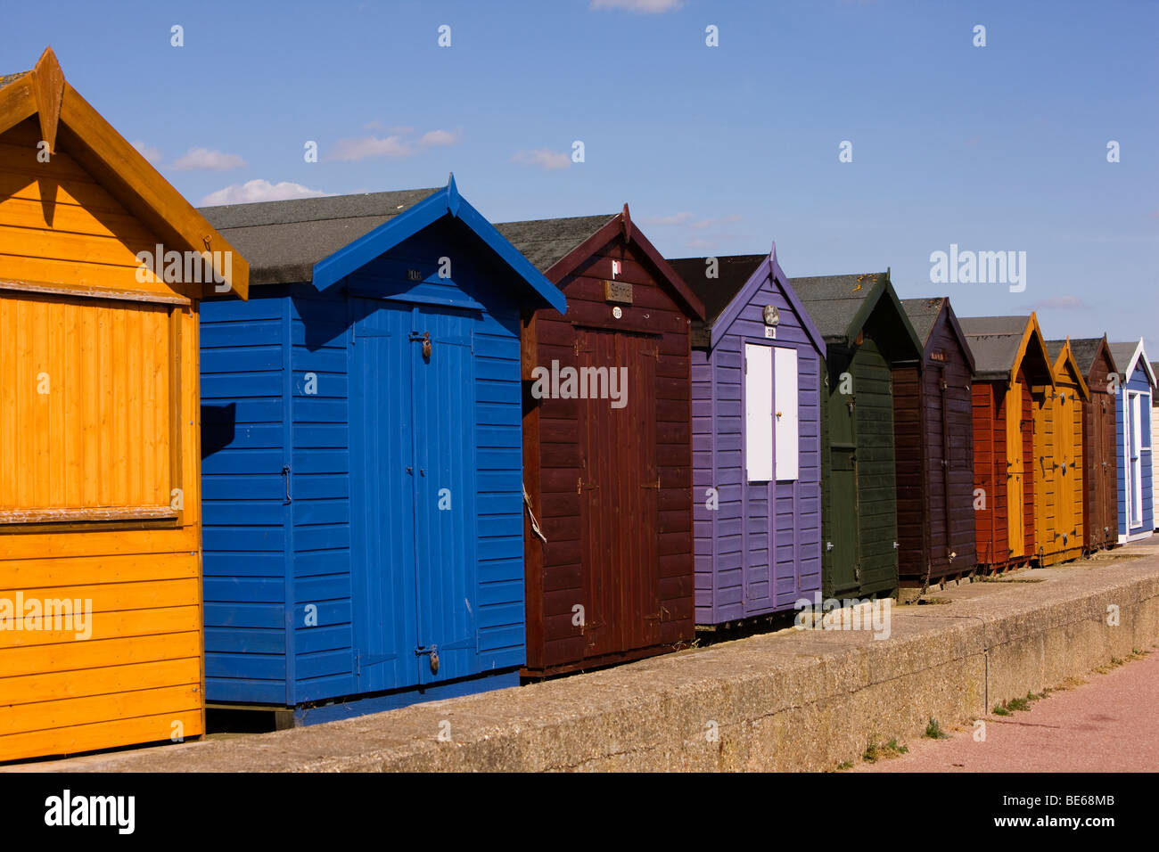 Die Hauptattraktion des Resorts sind bunt bemalt Strandhütten auf der Strandpromenade von Essex Küste Stadt von Brightlingsea Stockfoto
