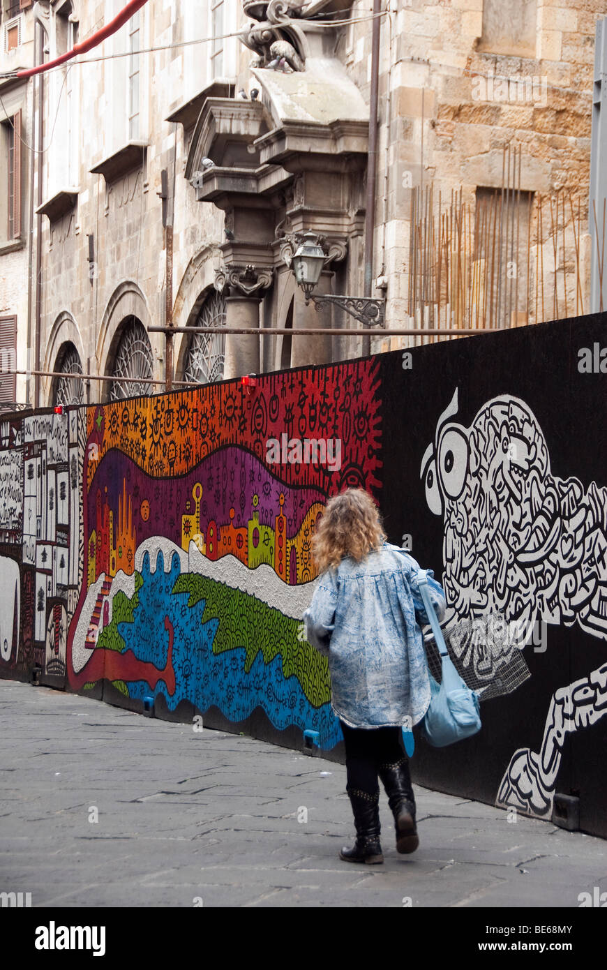 Frau zu Fuß vorbei an Straßenkunst in Pisa, Italien Stockfoto