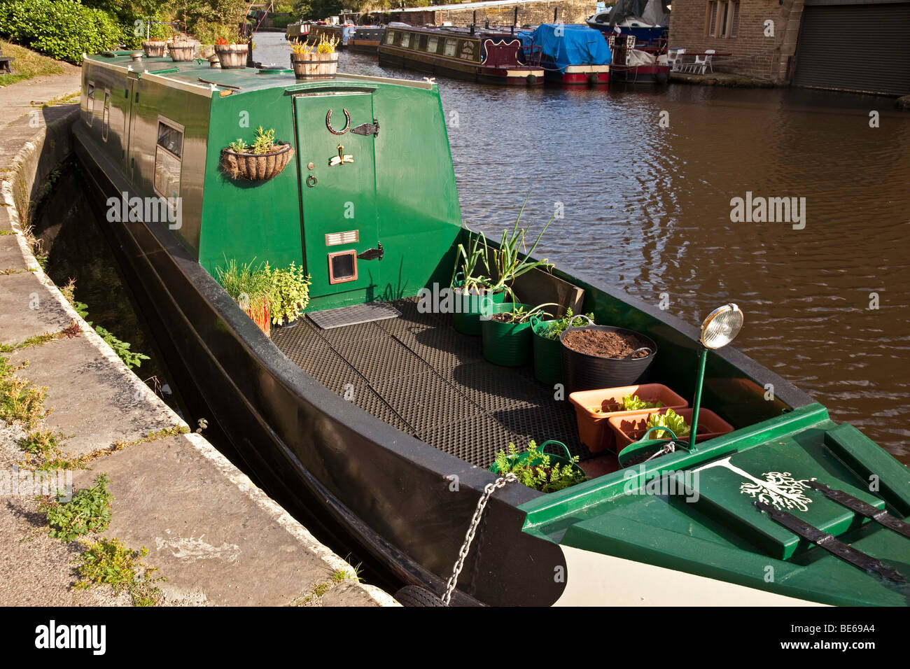 Schmale Boot mit Bio-Gemüse und Kräuter wachsen in Töpfen auf der Terrasse am Sowerby Bridge Canal Basin, Yorkshire Stockfoto