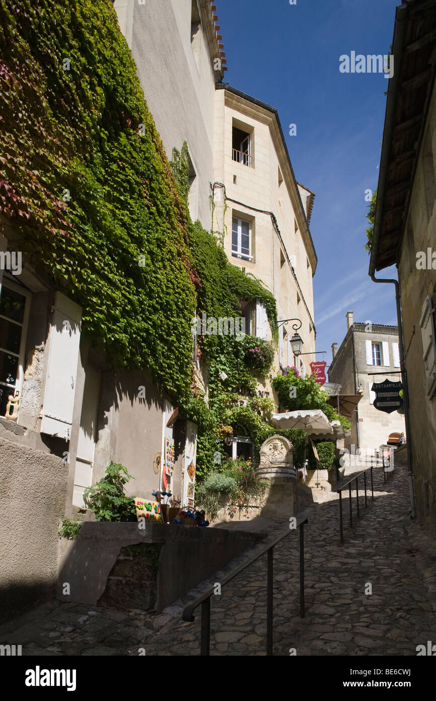 Ein steilen gepflasterten Weg führt bergauf vorbei an einem Restaurant in der Stadt Bordeaux Saint Emilion, Frankreich Stockfoto