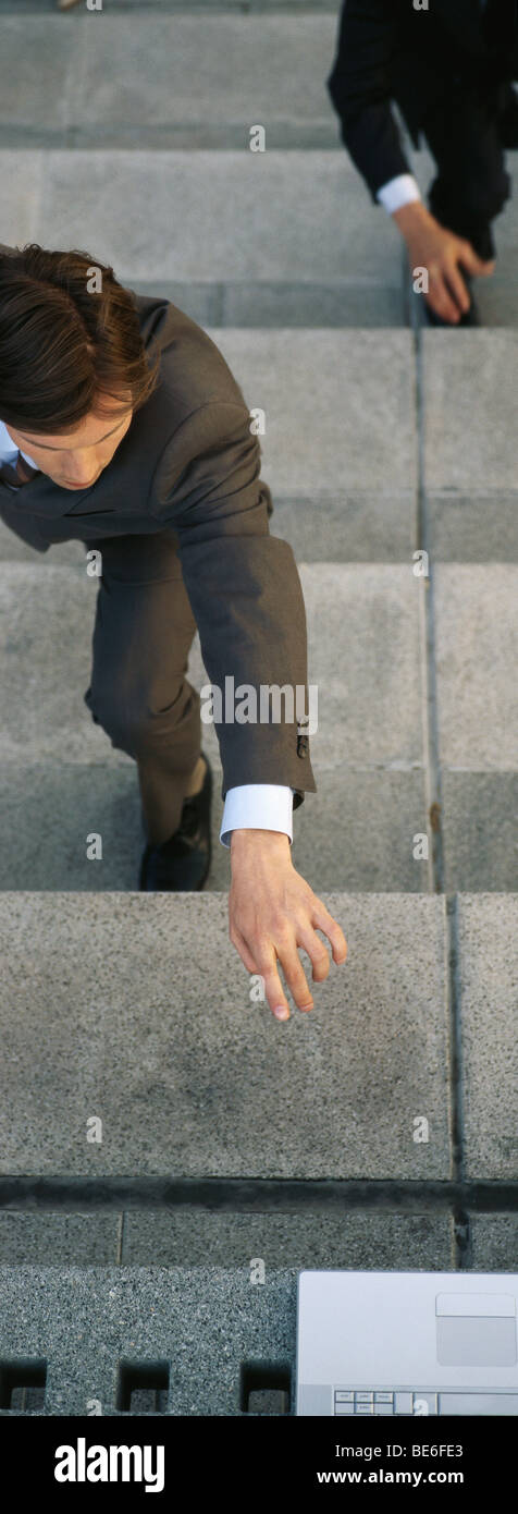 Geschäftsleute auf Schritte für Laptop-Computer an Spitze der Treppe zu erreichen Stockfoto