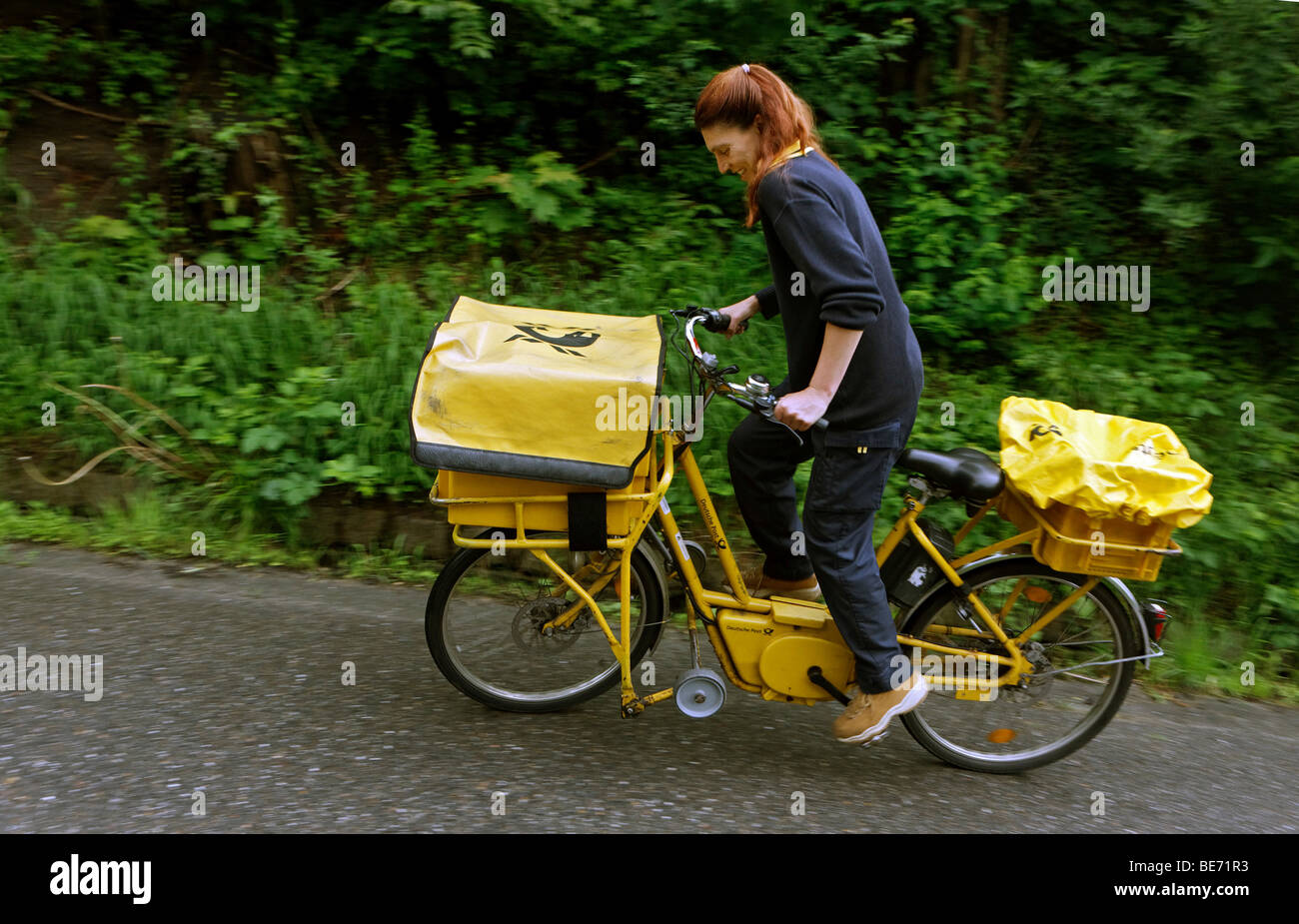 Briefzusteller Annerose Schulze fahren ihr Unternehmen Fahrrad in ihrem Bezirk für die Deutsche Post AG Deutsche Post in Sonnenberg in Stockfoto