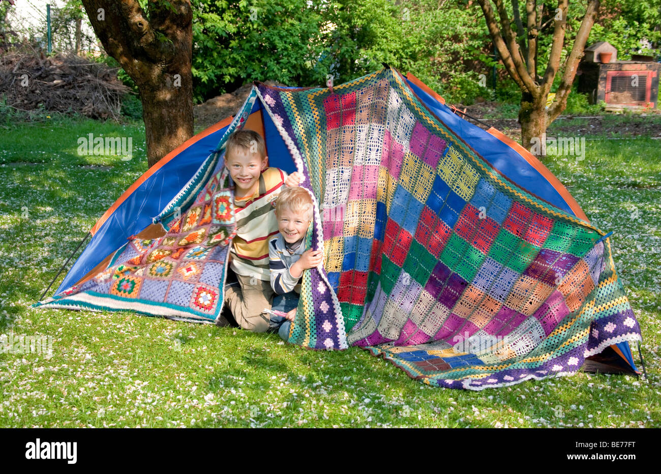 Zwei Jungs, 7 und 5, bauen ein Zelt im Garten Stockfoto