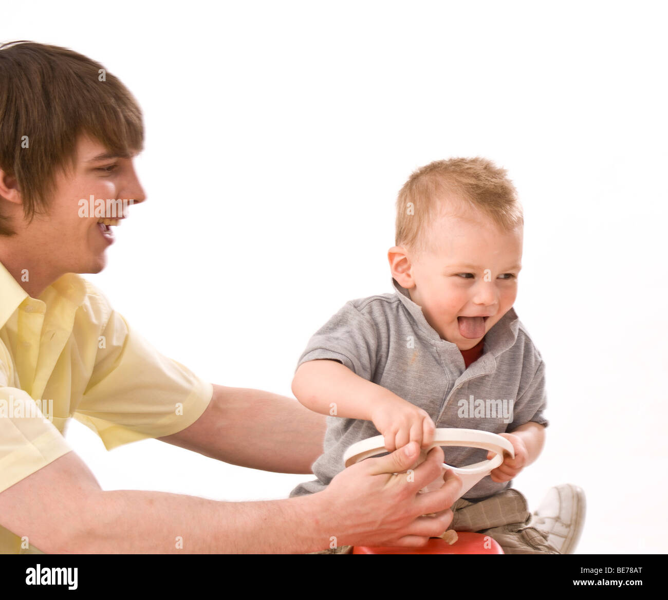 Junger Vater mit seinem Sohn auf dem Bobbycar spielen Stockfoto