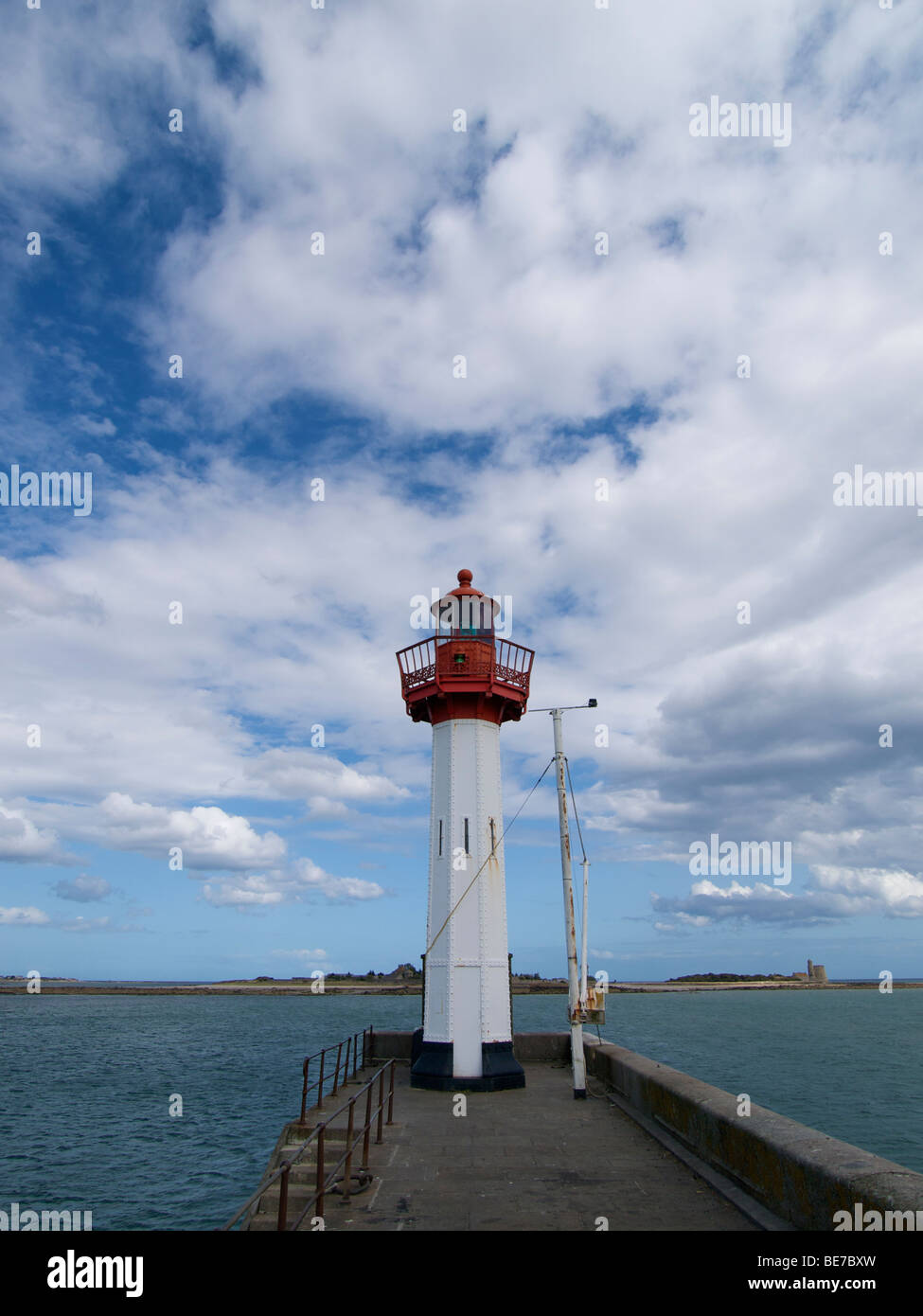 Kleiner Leuchtturm in den Hafen von St. Vaast la Hougue, Normandie, Frankreich mit Ile de Tatihou im Hintergrund Stockfoto