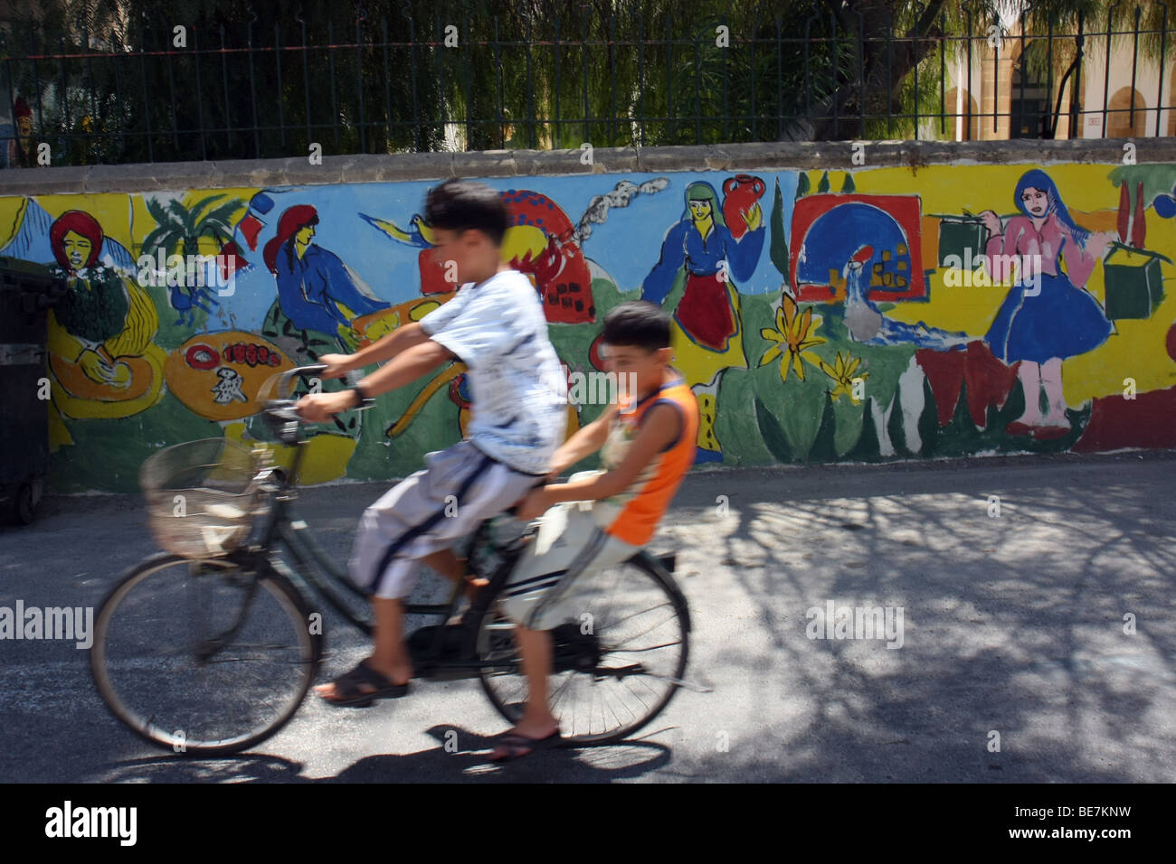 Zwei jungen auf einem Fahrrad neben einer bemalten Wand im nördlichen türkischen zypriotischen Teil von Nikosia. Stockfoto