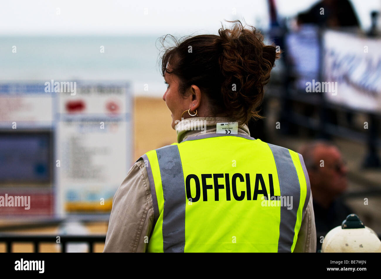 Eine Frau trägt ein hi-viz Jacke mit Beamten, die auf die Rückseite geschrieben. Stockfoto