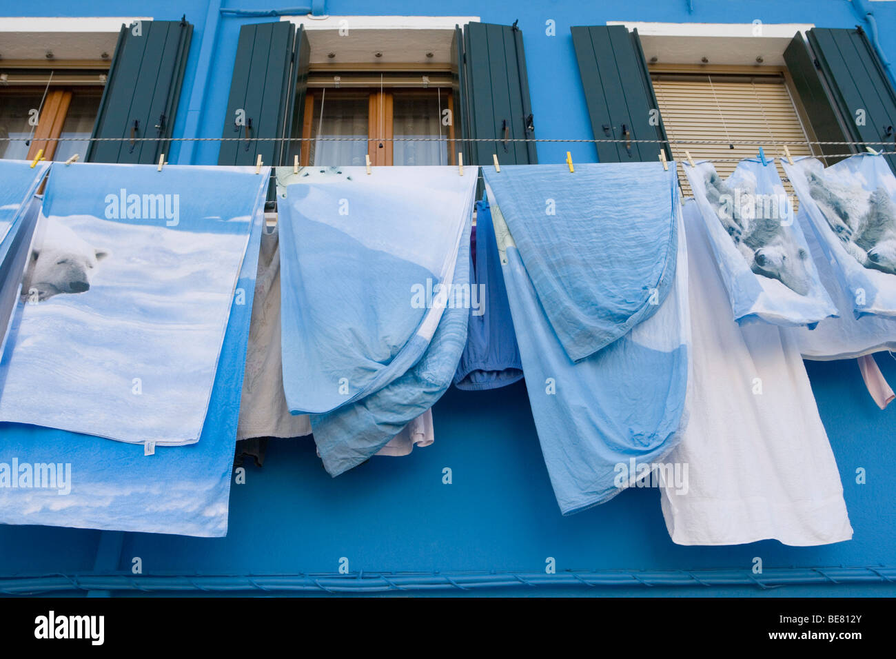 Eisbär-Bettdecken Trocknung auf eine Wäscheleine vor einem blau lackierten Haus, Burano, Veneto, Italien Stockfoto