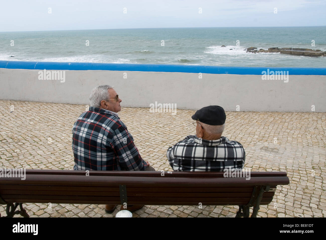 Zwei ältere Männer, Fischer, sitzen auf einer Bank, Blick aufs Meer, Ericeira, Portugal, Atlantik Stockfoto