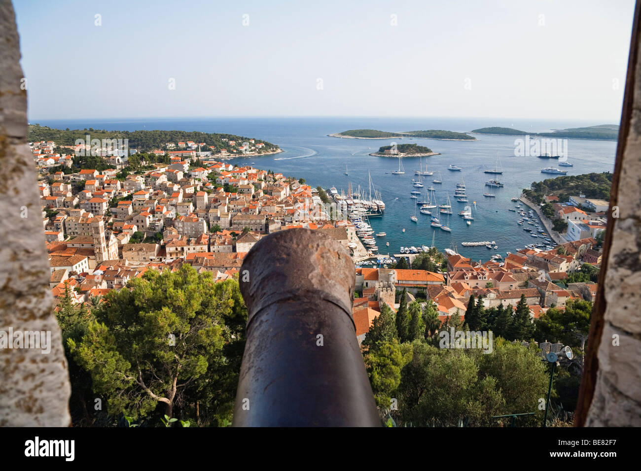 Blick über eine Kanone auf Häuser und den Hafen von Hvar, Insel Hvar, Dalmatien, Kroatien, Europa Stockfoto