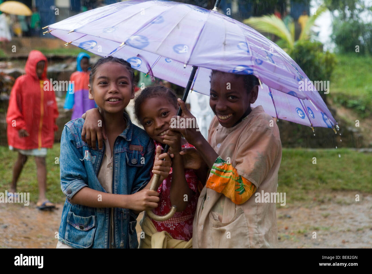 Es regnet und wir kümmern uns nicht! Glückliche Kinder in den Regen, Ambodifototra, Nosy St. Marie, Madagaskar, Afrika Stockfoto