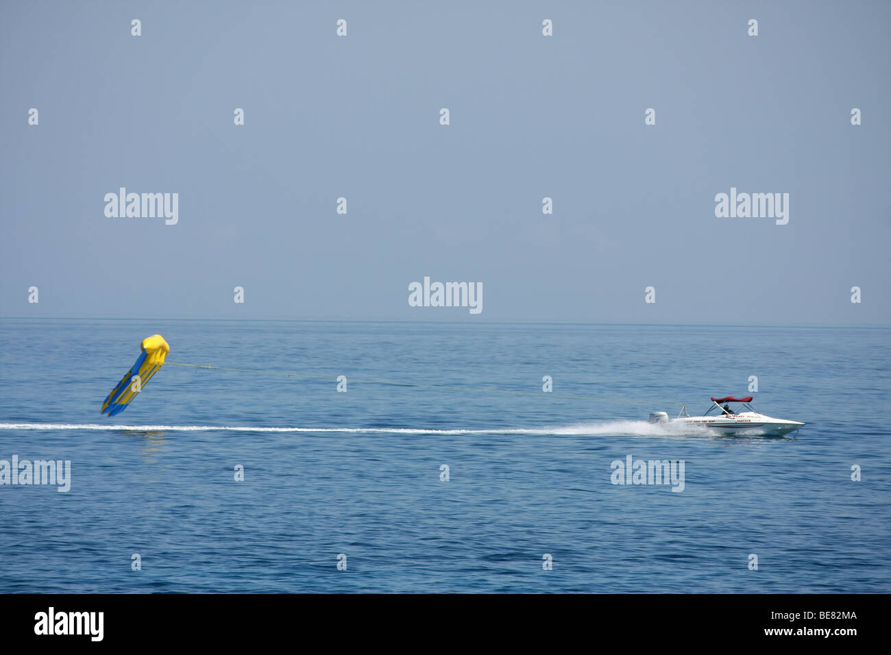 Touristen, die Spaß, Reiten in der aufblasbaren Flyfish, mit hoher Geschwindigkeit nach einem Motorboot, Fig Tree Bay, Protaras, Zypern. Stockfoto