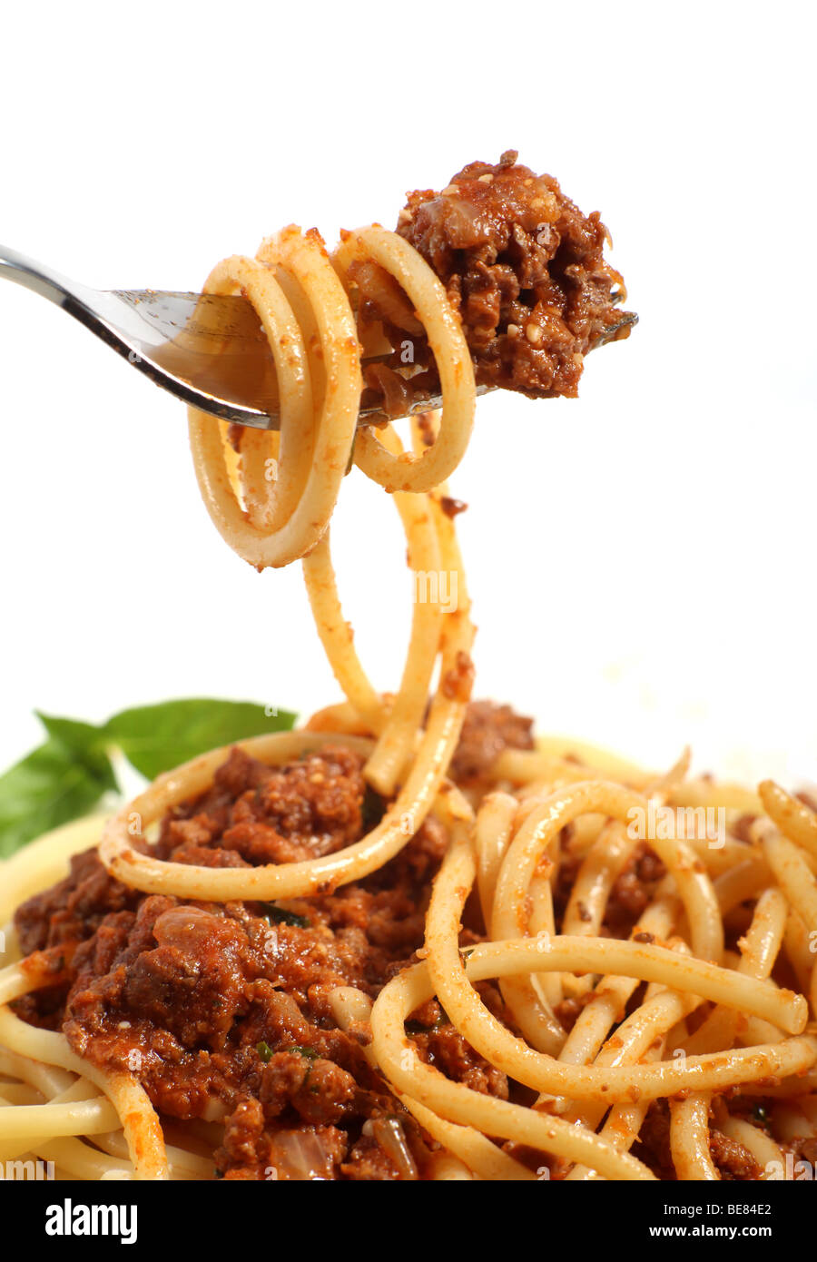 Eine Gabel heben Spaghetti Bolognese über eine Platte von der gleichen Stockfoto