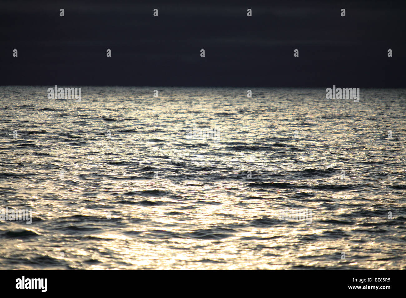 Das Sonnenlicht reflektiert durch Gewitterwolken, auf hoher See Stockfoto