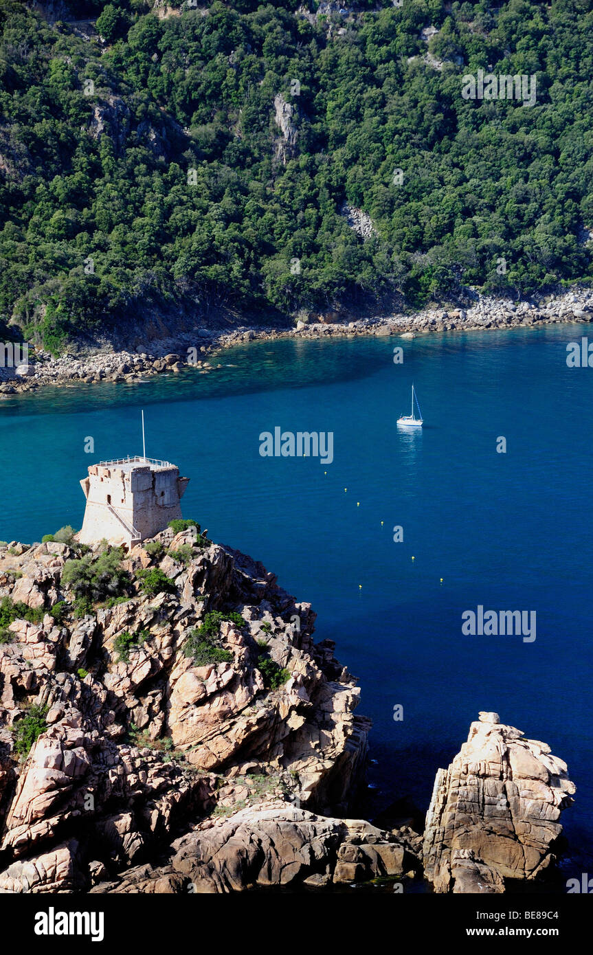 Frankreich Mittelmeer Korsika Golfe Di Porto, Porto genuesischen Turm auf felsigen Landzunge mit blauem Wasser und Boote. Stockfoto