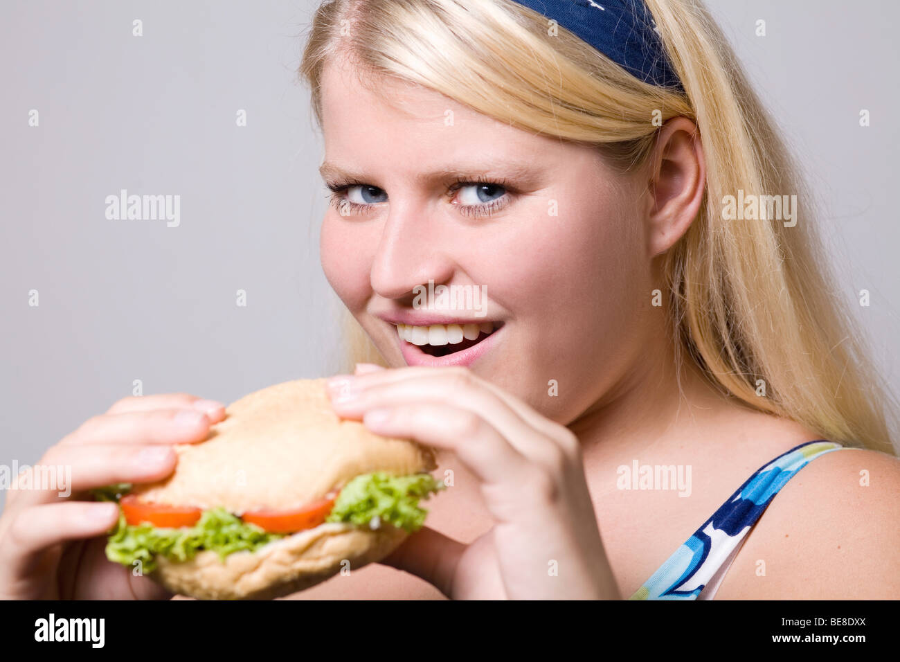 Junge fette Frau ist Fast-Food-Hamburger Essen. Stockfoto
