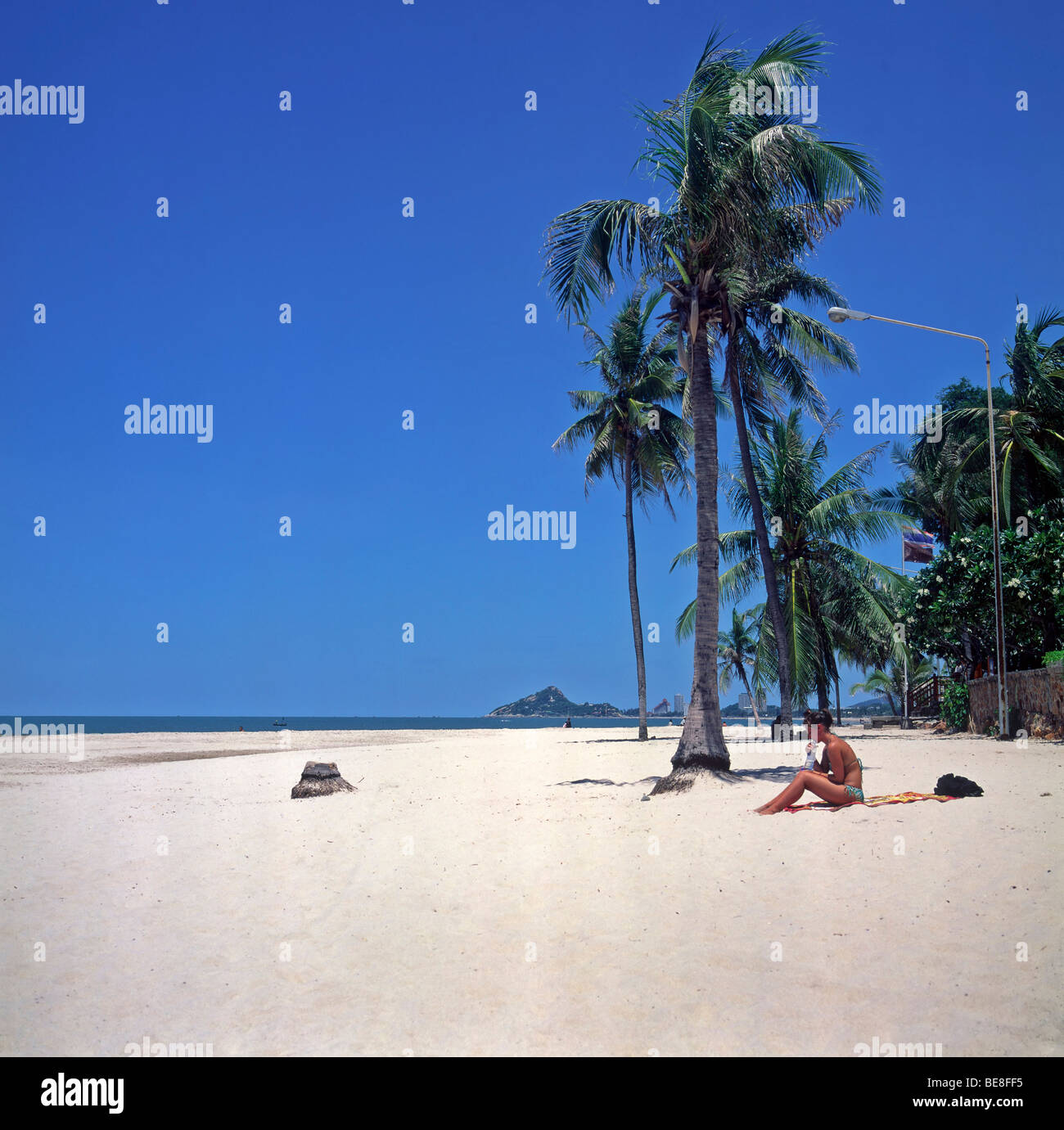 Hua Hin, Thailand. Nur Frau tropischer Strand genießt die Einsamkeit eines wunderschönen tropischen Strandes mit tiefblauem Sommerhimmel und Palmen. Stockfoto