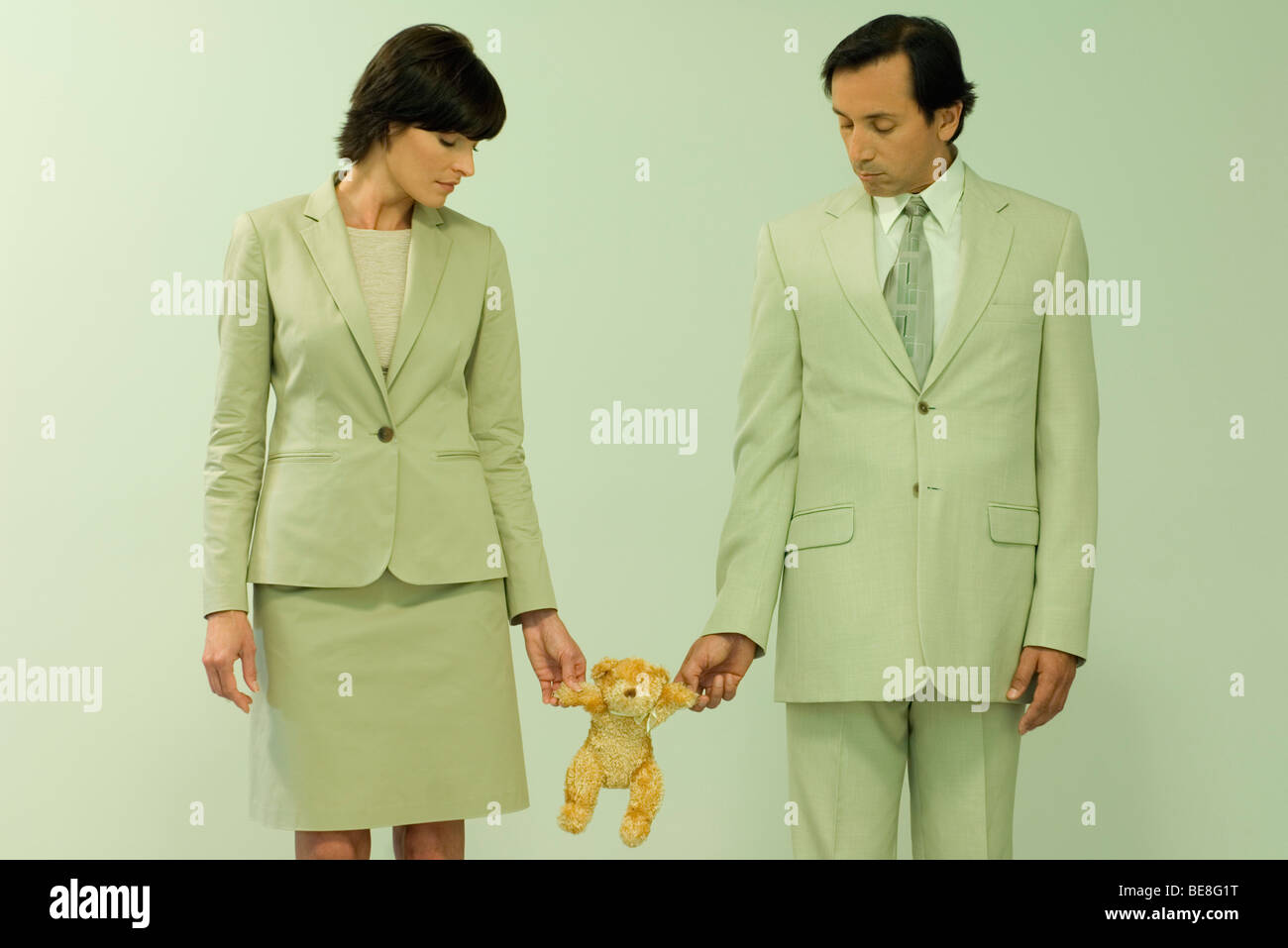 Professionelle paar stehen zusammen blickte auf Teddybär statt zwischen Ihnen Stockfoto
