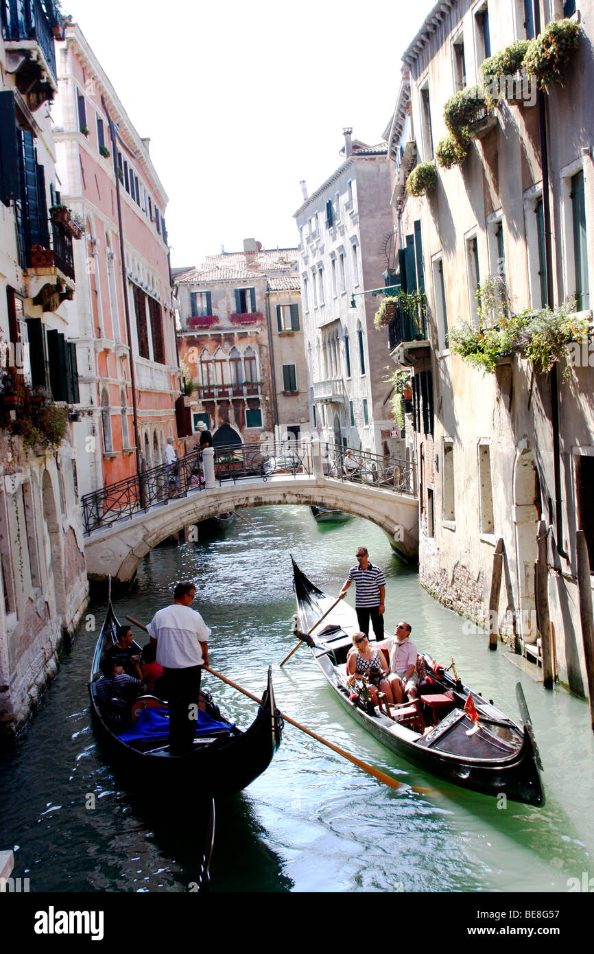 Eine Bootsfahrt durch die wunderschönen Grachten der Stadt übernehmen Gondolieri Touristen nach Venedig. Italien Stockfoto