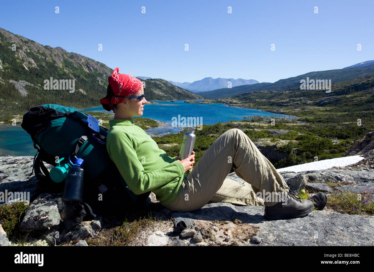 Junge Frau ruht, Wanderer mit Rucksack, Trinkflasche, Panorama, tiefer See hinter historischen Chilkoot Trail, Chilkoot Pass, alp Stockfoto