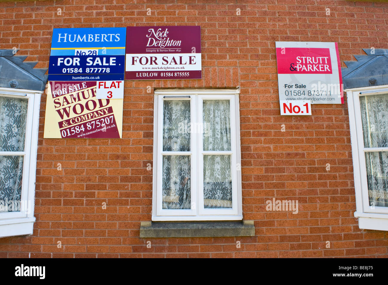 Wohnungen mit Immobilienmaklern Boards außerhalb zu verkaufen und zu vermieten in Ludlow Shropshire England UK Stockfoto