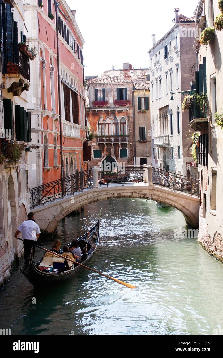 Eine Bootsfahrt durch die wunderschönen Grachten der Stadt übernehmen Gondolieri Touristen nach Venedig. Italien Stockfoto