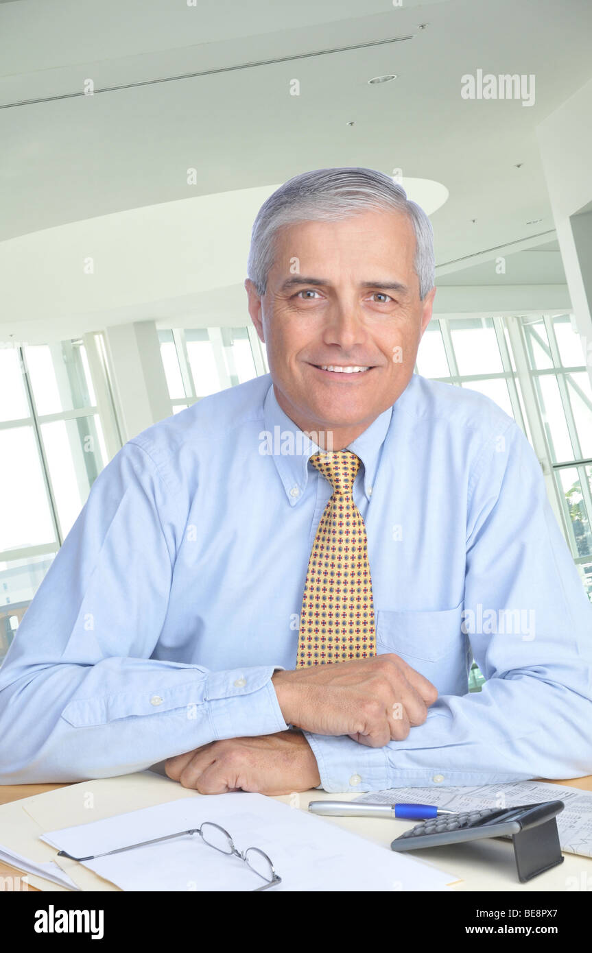 Geschäftsmann sitzt an seinem Schreibtisch in modernen Büroumgebung Stockfoto
