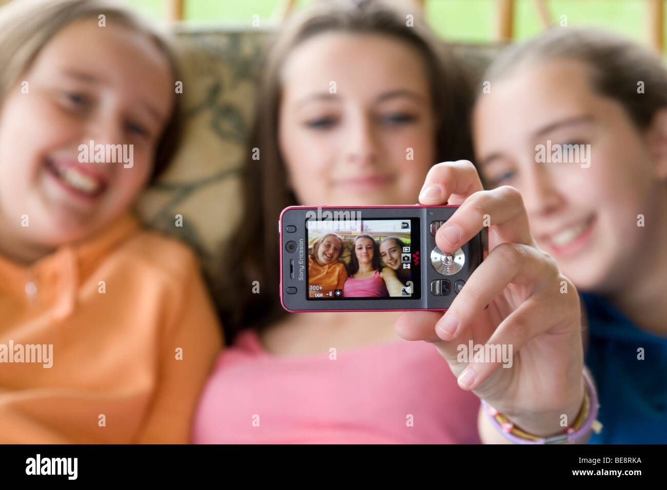 Drei Schwestern, die mit dem Handy telefonieren, um ein Selbstporträt zu nehmen. Stockfoto