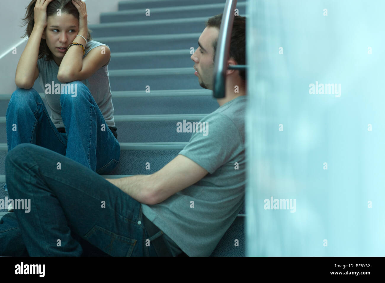 Junges Paar sitzt auf der Treppe, angespannten Gespräch Stockfoto