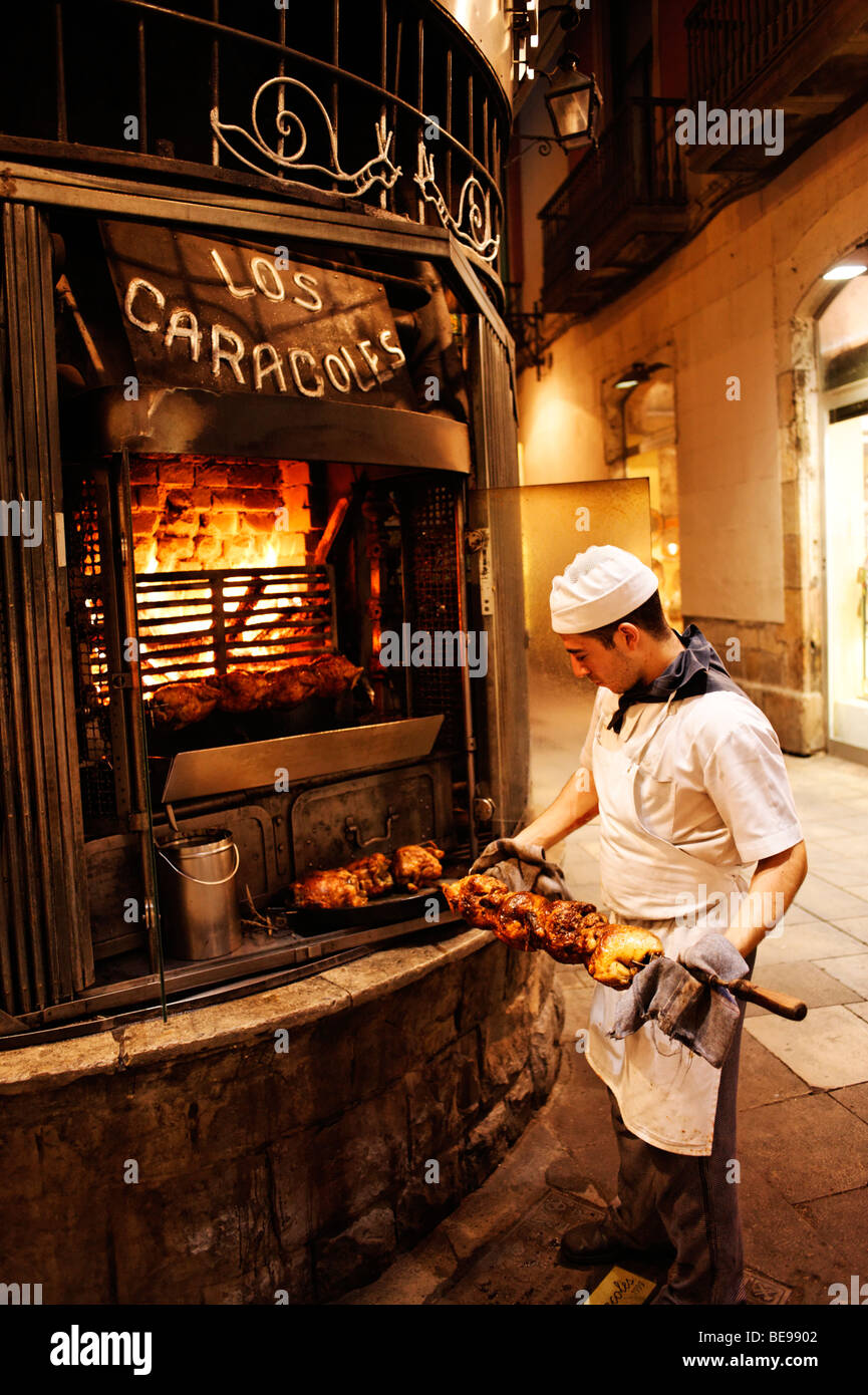 Koch Braten Hähnchen am Spieß vor Los Caracoles Restaurant. Barri Gottic. Barcelona. Spanien Stockfoto