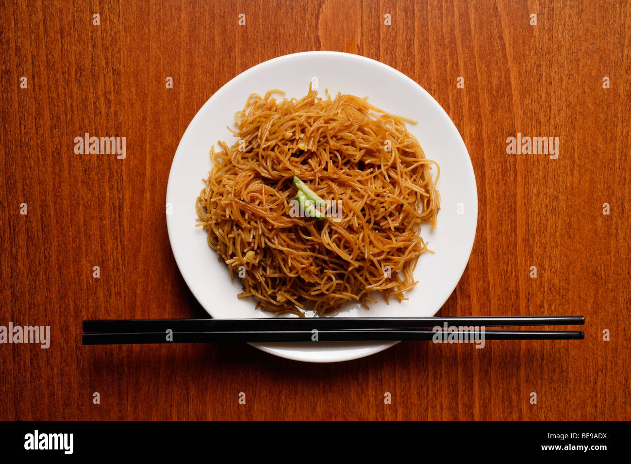 Chinesische Nudeln auf Teller mit Stäbchen. Stockfoto