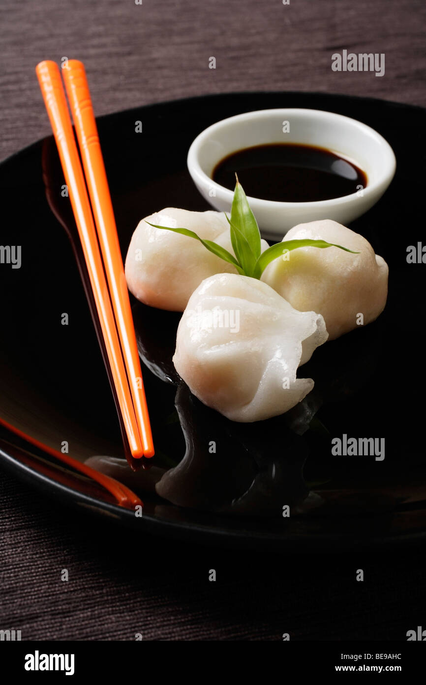 Dim-Sum auf Teller mit orange Stäbchen Stockfoto