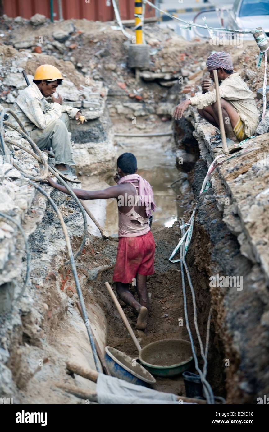 Bauarbeiter nehmen eine Teepause in einem Graben in Connaught Place, Neu Delhi, Indien Stockfoto