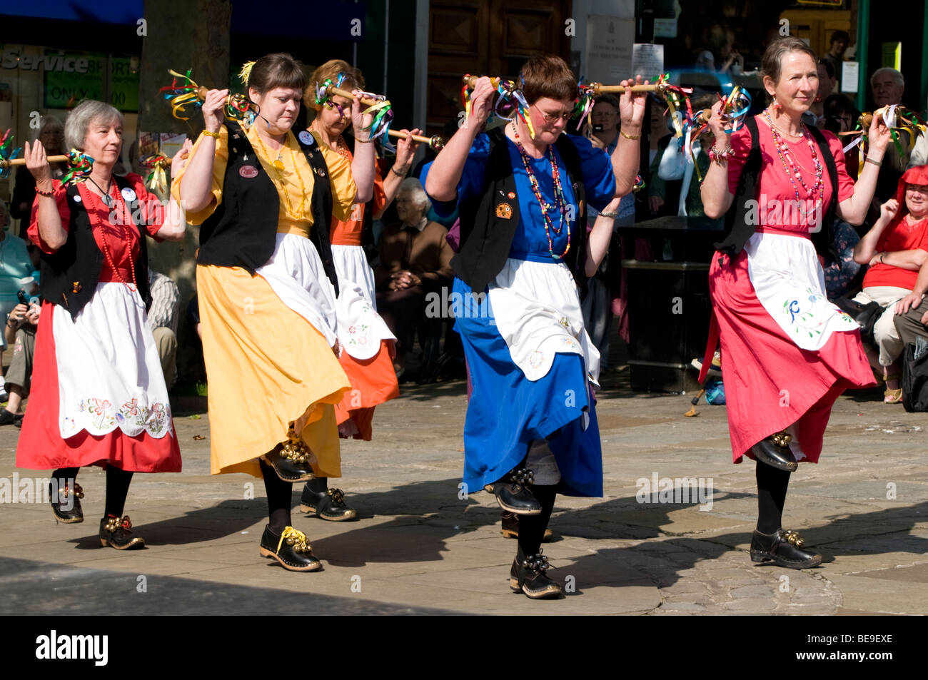 Frauen in hell farbige Kleider tanzen für Scharen von Schaulustigen Chesterfield Derbyshire England Stockfoto