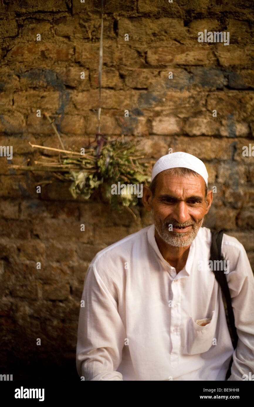 Ein Alter Mann wartet darauf, dass das Abendgebet zu starten in einer Straße in Nizamuddin, New Delhi, Indien Stockfoto