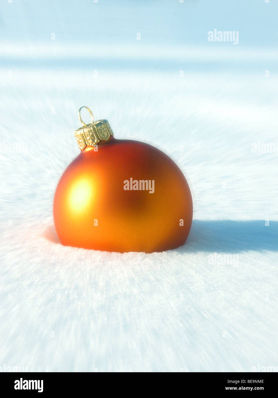 Christbaumkugel Kugel Orange im Schnee - Orangene Christbaumkugel Im Schnee Stockfoto
